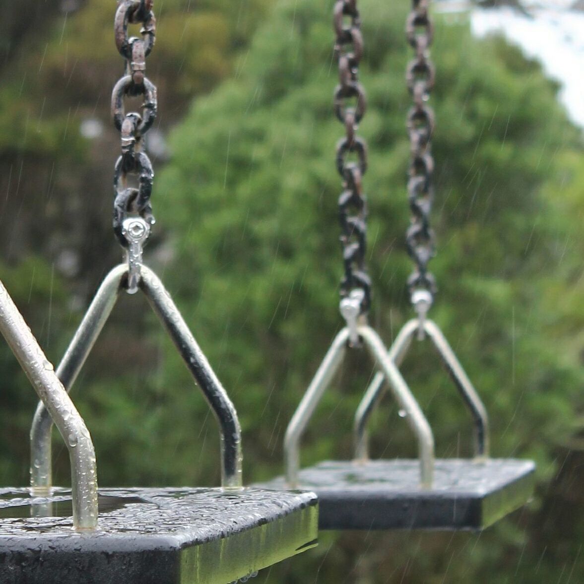 CLOSE-UP OF CHAIN HANGING ON METALLIC STRUCTURE