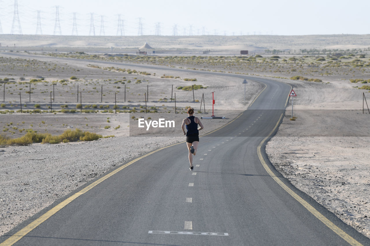 Rear view of man walking on road