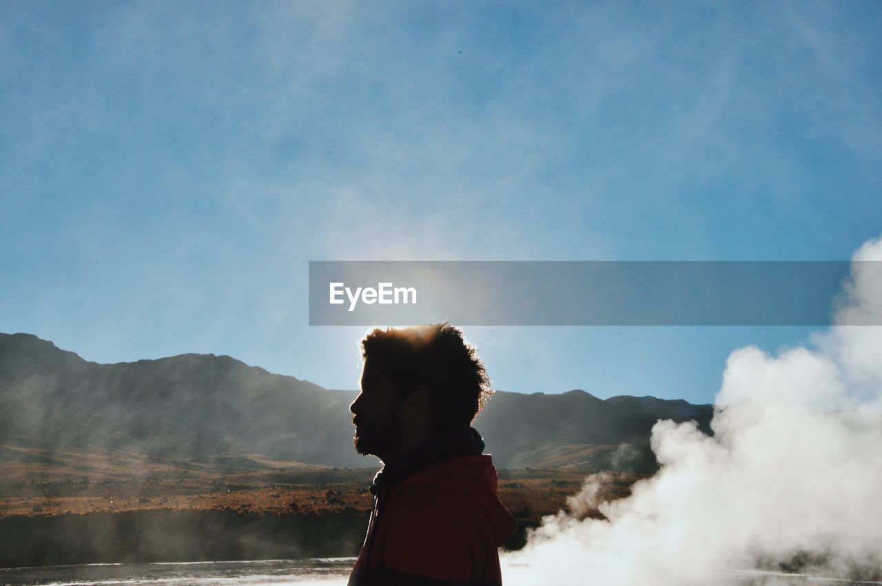 Side view of silhouette woman standing with mountains