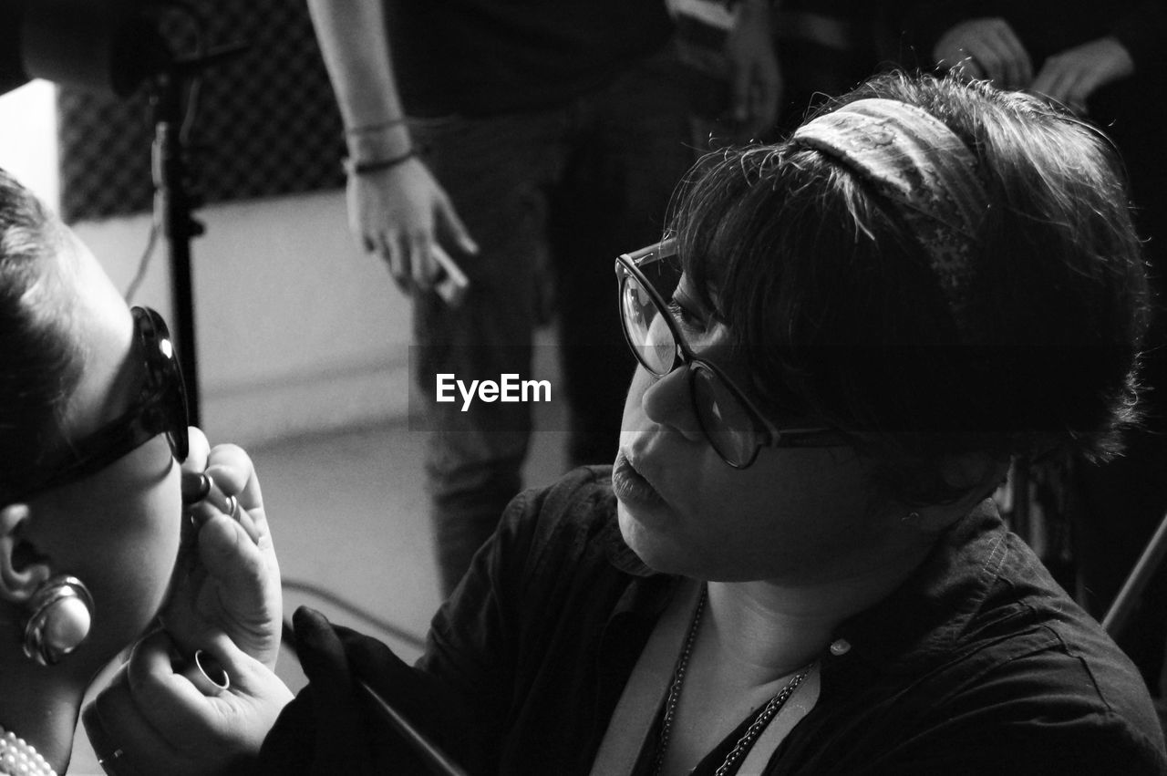 Close-up of make-up artist applying lipstick on woman