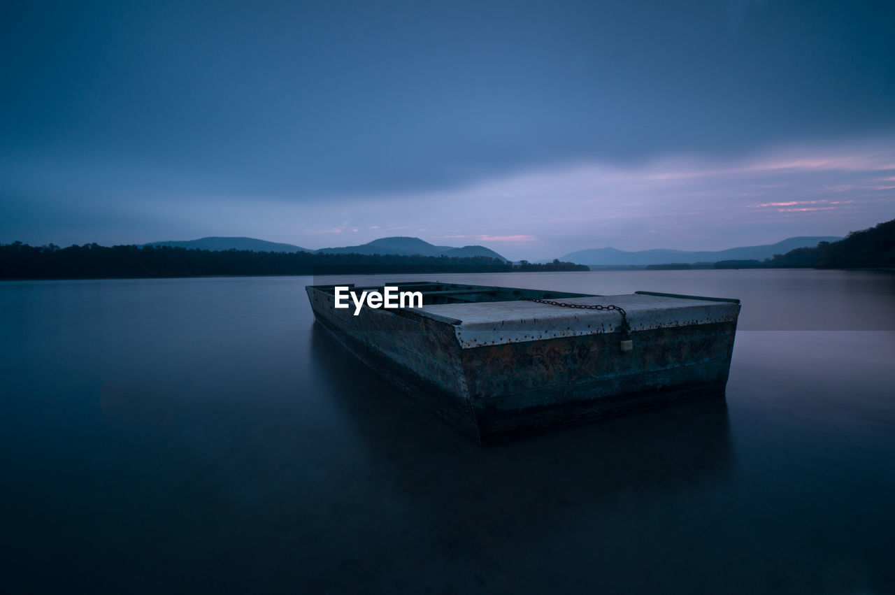 Scenic view of lake against sky at dusk