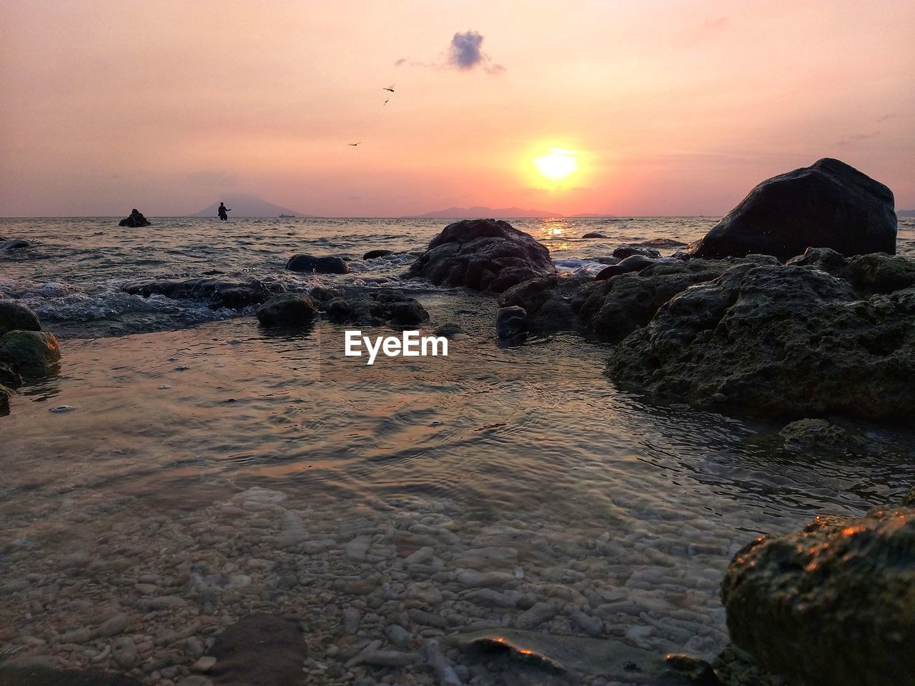 ROCKS ON BEACH AGAINST SKY DURING SUNSET