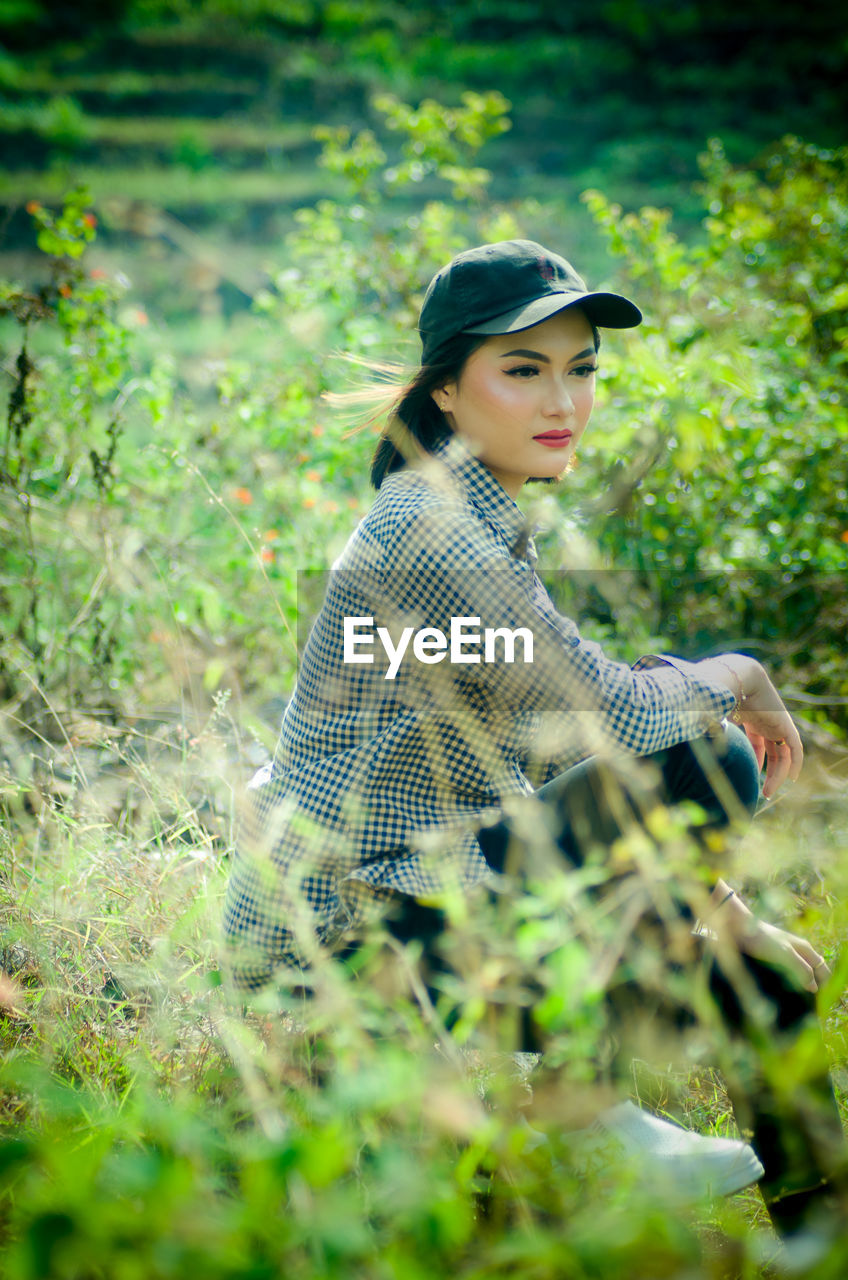 Woman sitting outdoor at hiking pole and take a photoshoot