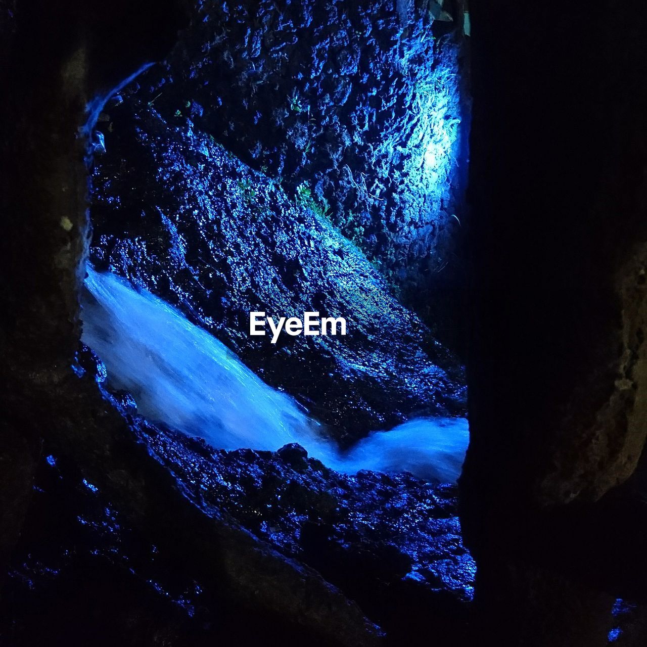 CLOSE-UP OF ILLUMINATED CAVE IN WATER