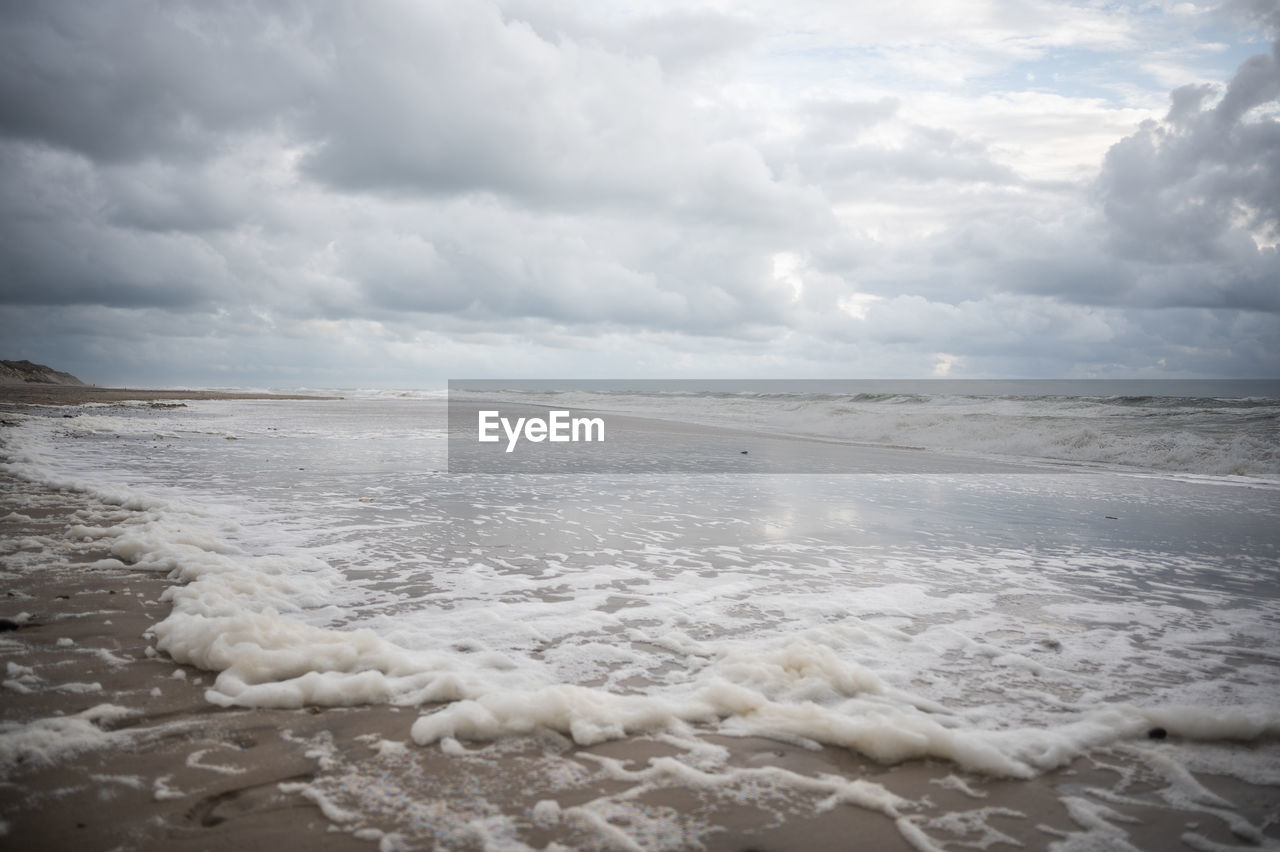 cloud, sky, sea, water, land, beach, wind wave, wave, beauty in nature, scenics - nature, ocean, environment, nature, shore, sand, landscape, storm, coast, snow, motion, dramatic sky, surfing, water sports, body of water, horizon, overcast, storm cloud, cloudscape, winter, tranquility, outdoors, day, horizon over water, travel, travel destinations, freezing, sports, wet, ice, sunlight, tranquil scene, tourism, cold temperature