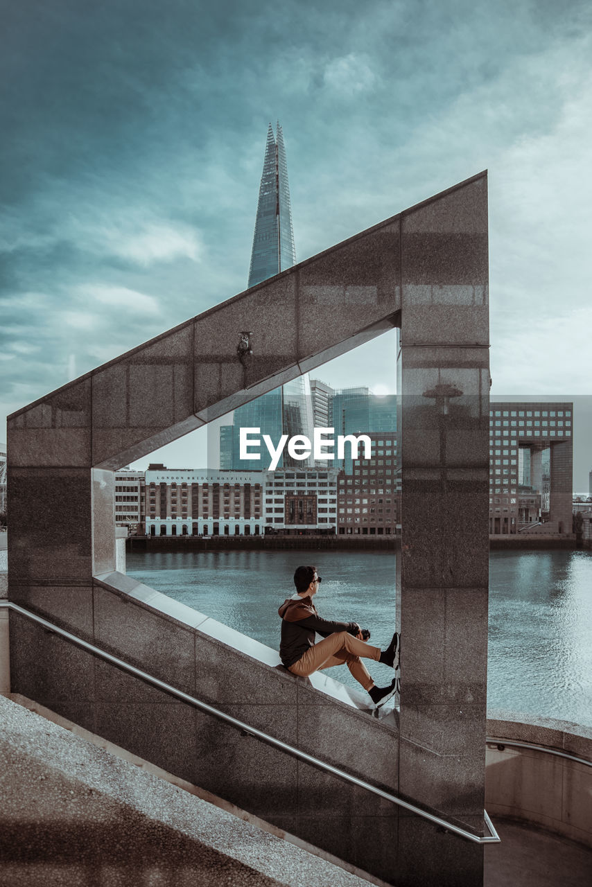 MAN AND BUILDING AGAINST SKY