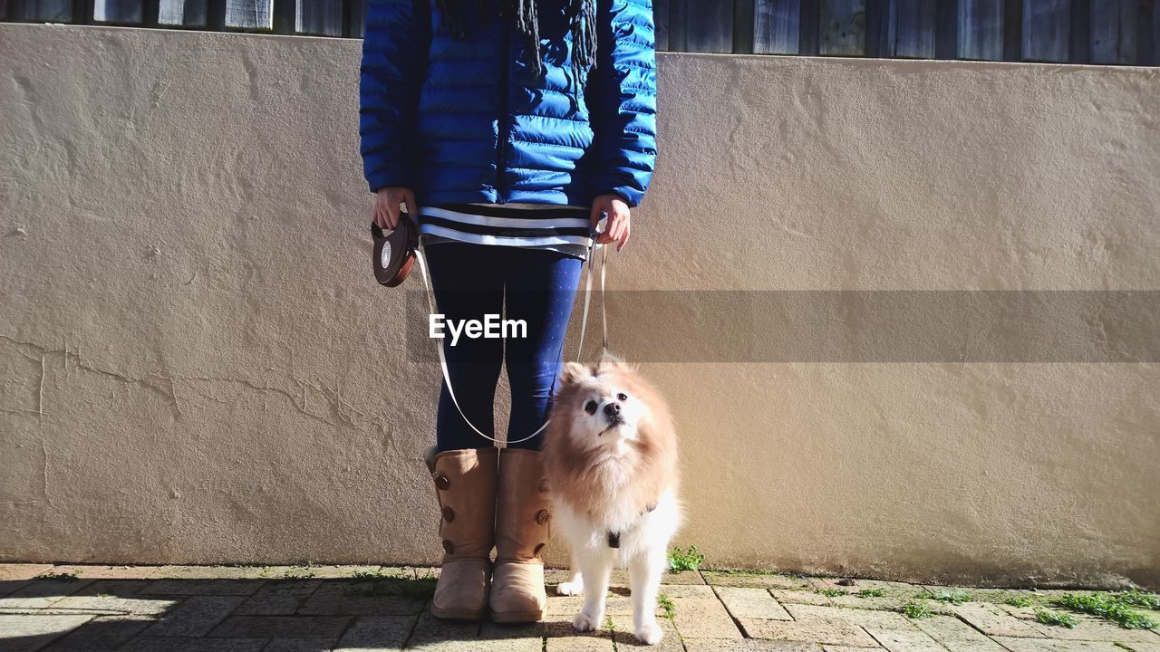 Woman standing with dog on street