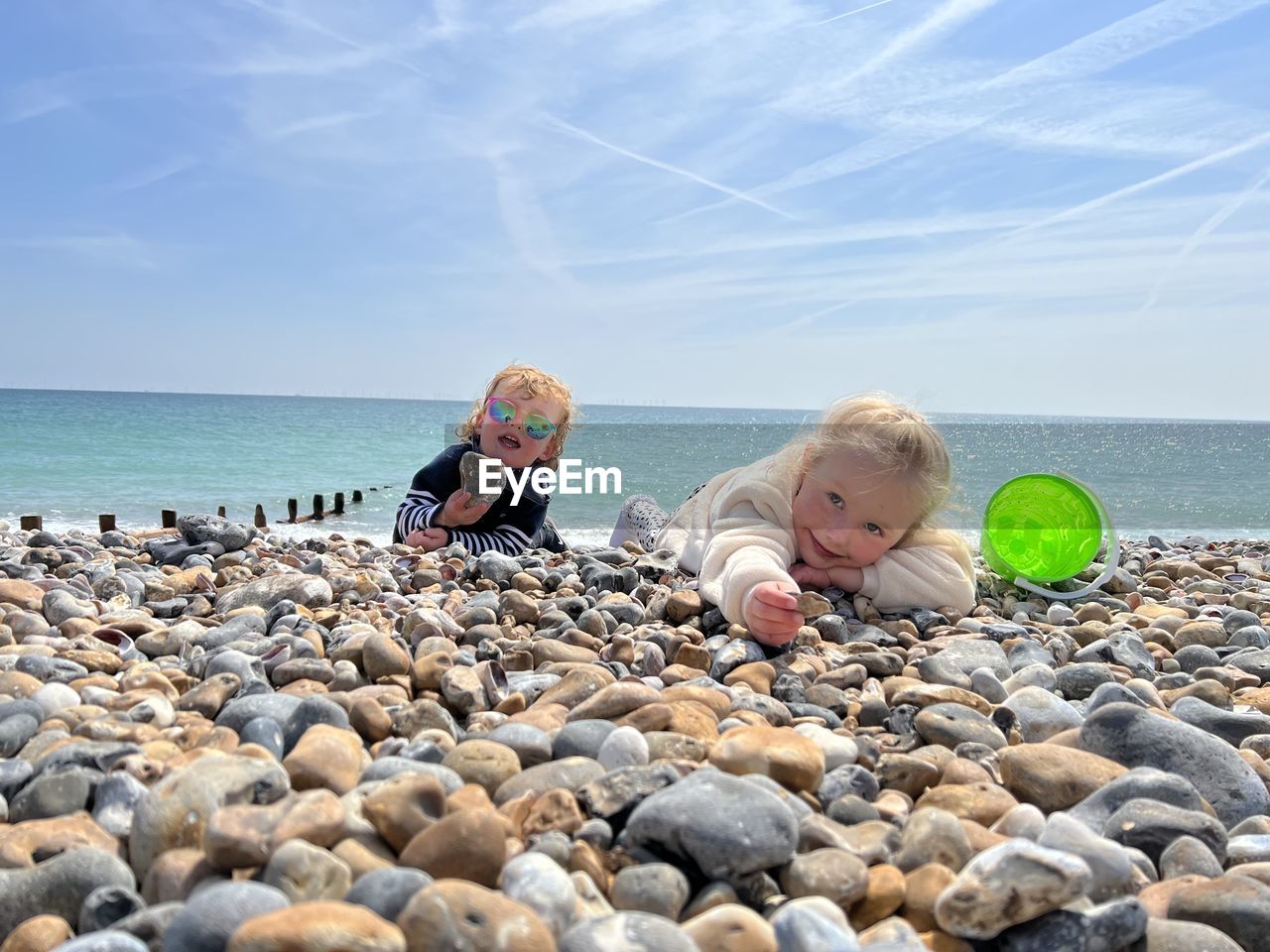 Rear view of children sitting on beach