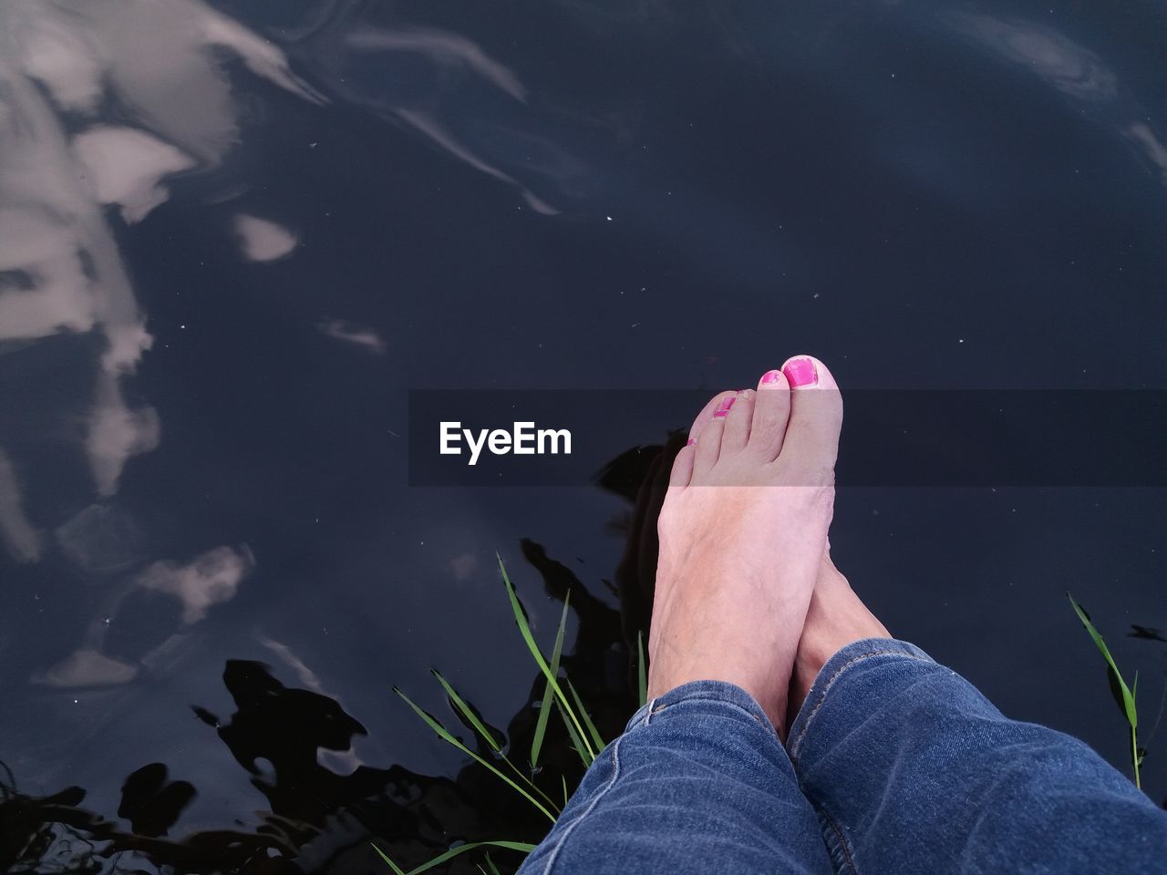 LOW SECTION OF WOMAN LEGS AGAINST WATER