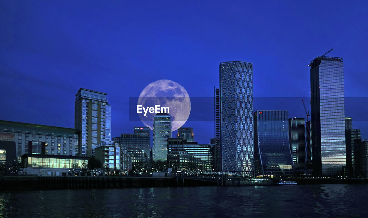 Modern buildings in city with full moon