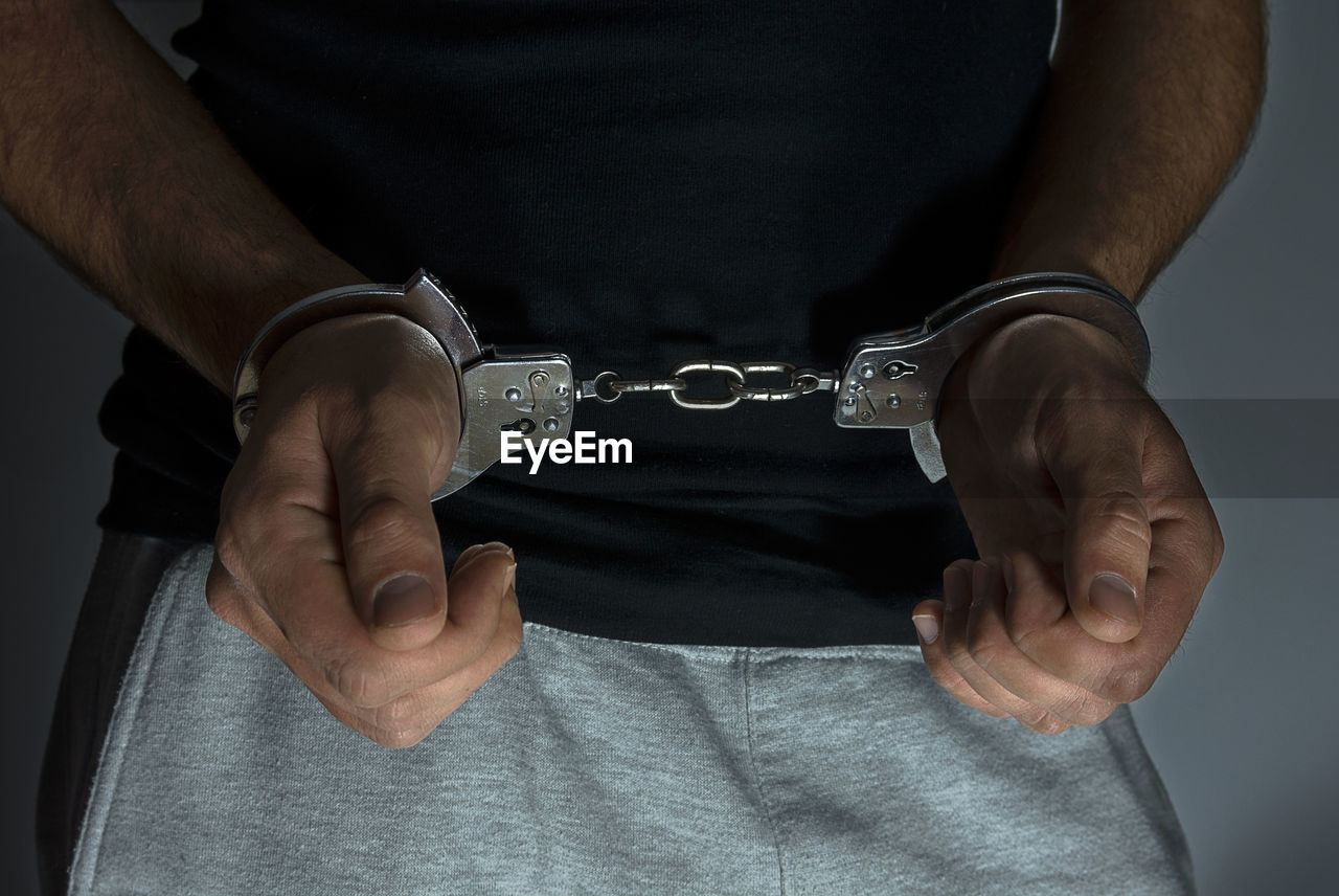 Midsection of man with hand cuffs