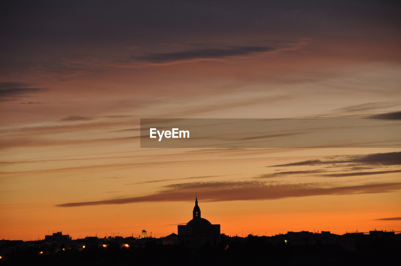 SILHOUETTE OF BUILDINGS AGAINST SKY DURING SUNSET