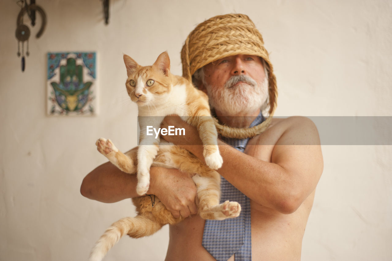 Man holding cat at home