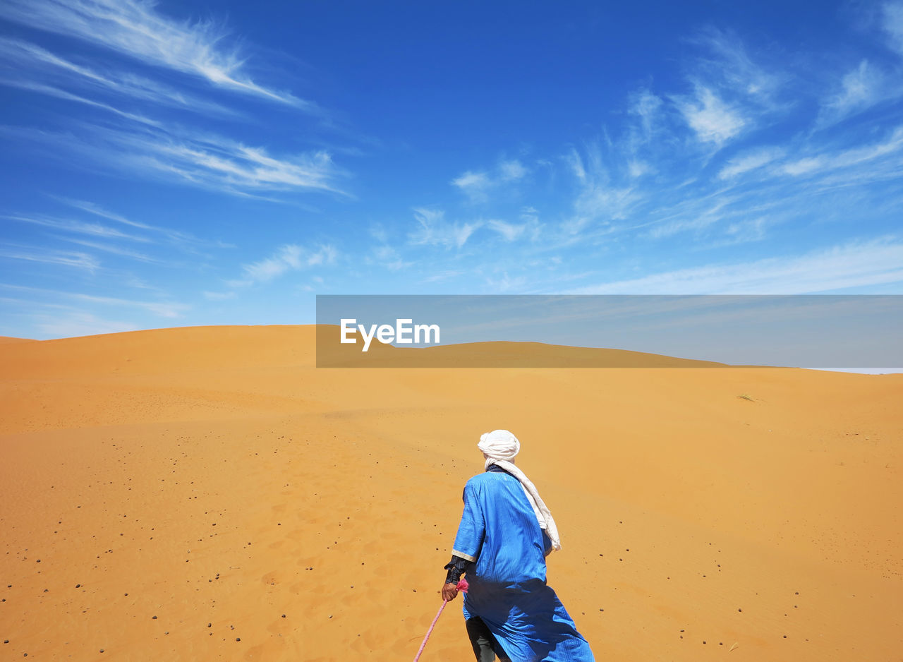 MAN ON DESERT AGAINST SKY