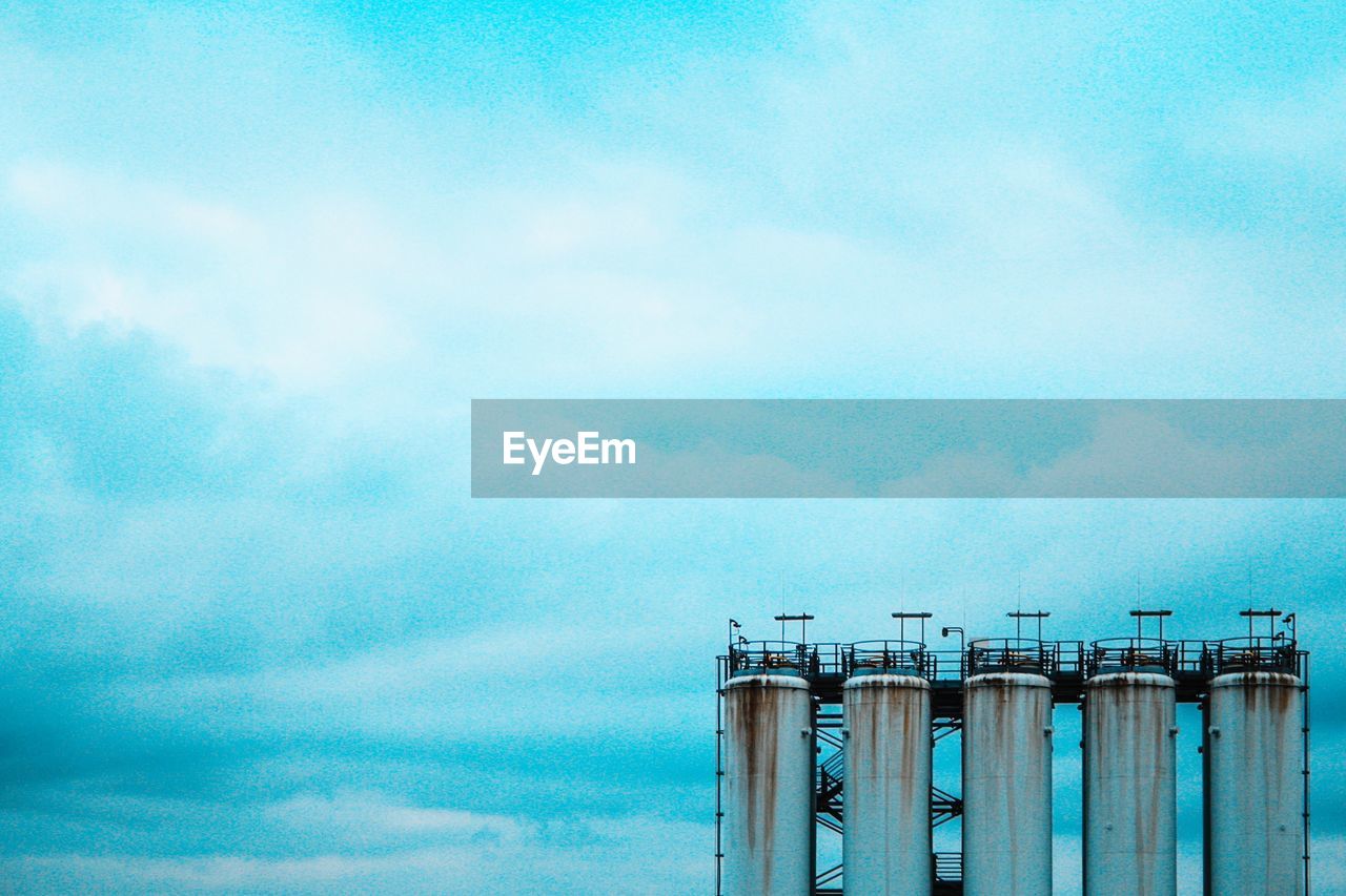 LOW ANGLE VIEW OF SMOKE STACKS AGAINST SKY