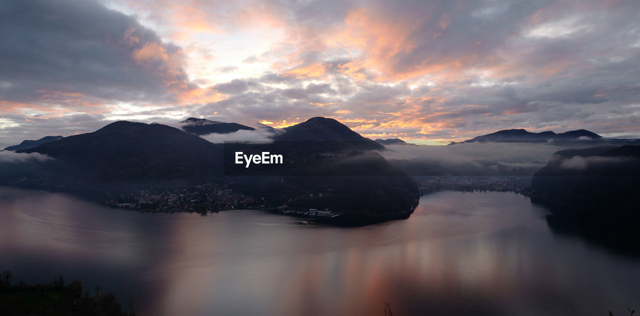 Scenic view of lake and mountains against sky during sunset