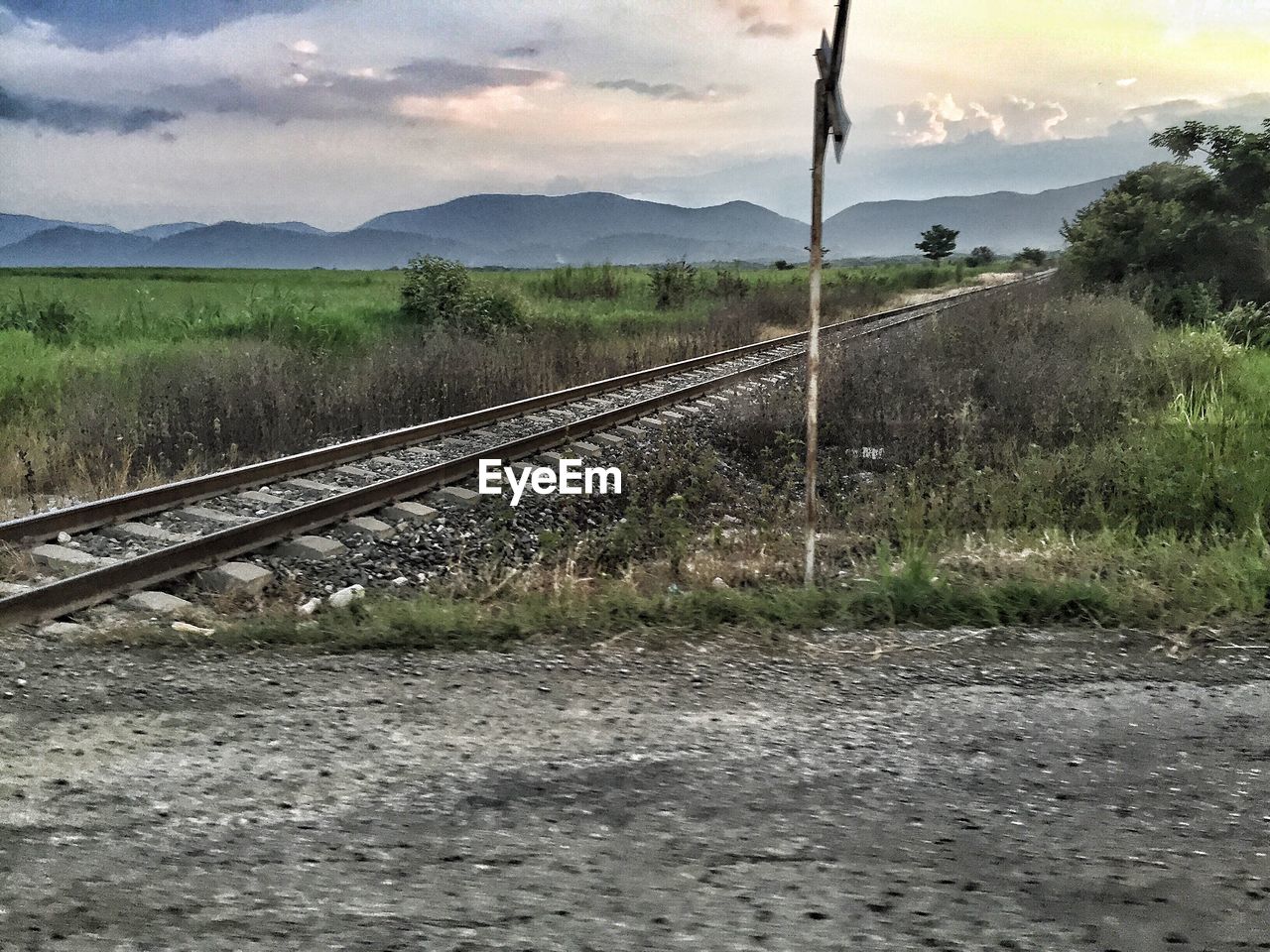 Railroad tracks by mountain against sky