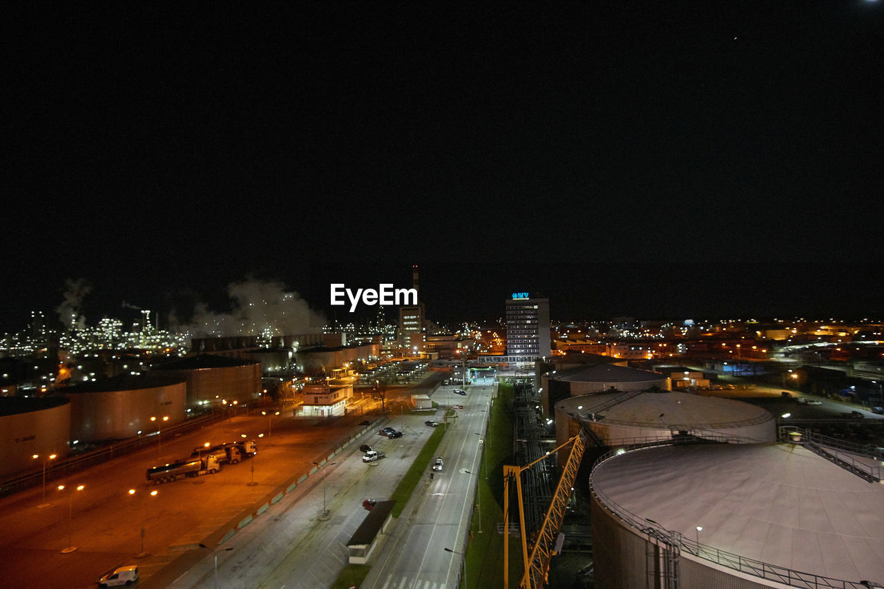 HIGH ANGLE VIEW OF ILLUMINATED CITYSCAPE AGAINST SKY