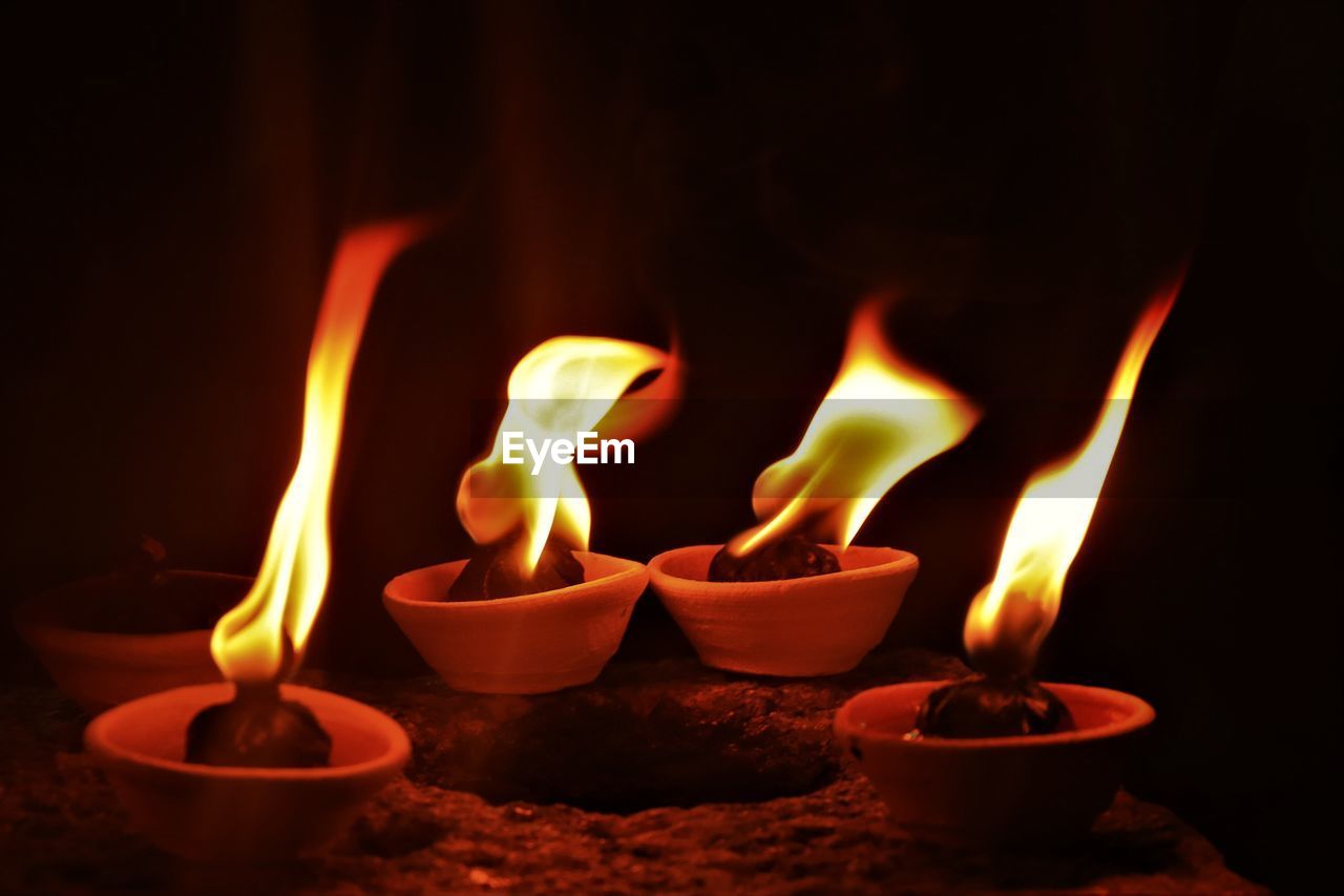 Close-up of diyas burning in temple