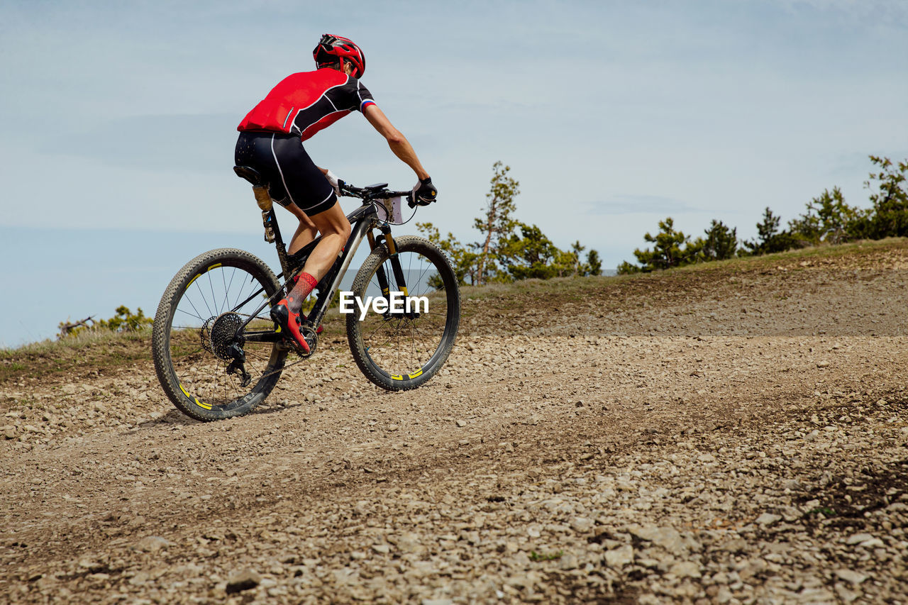 Athlete cyclist riding uphill trail on mountain bike