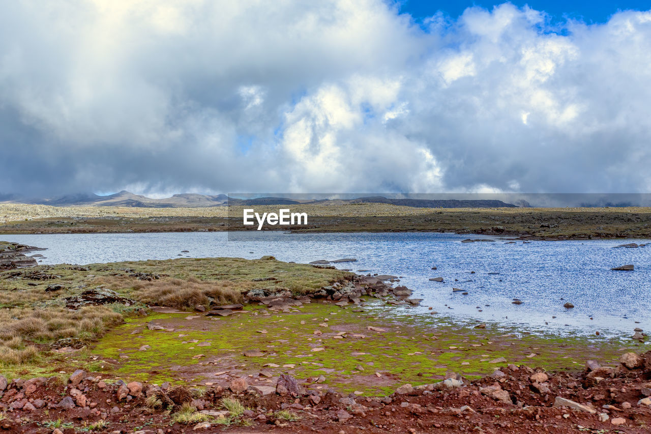 SCENIC VIEW OF LAKE AGAINST CLOUDY SKY