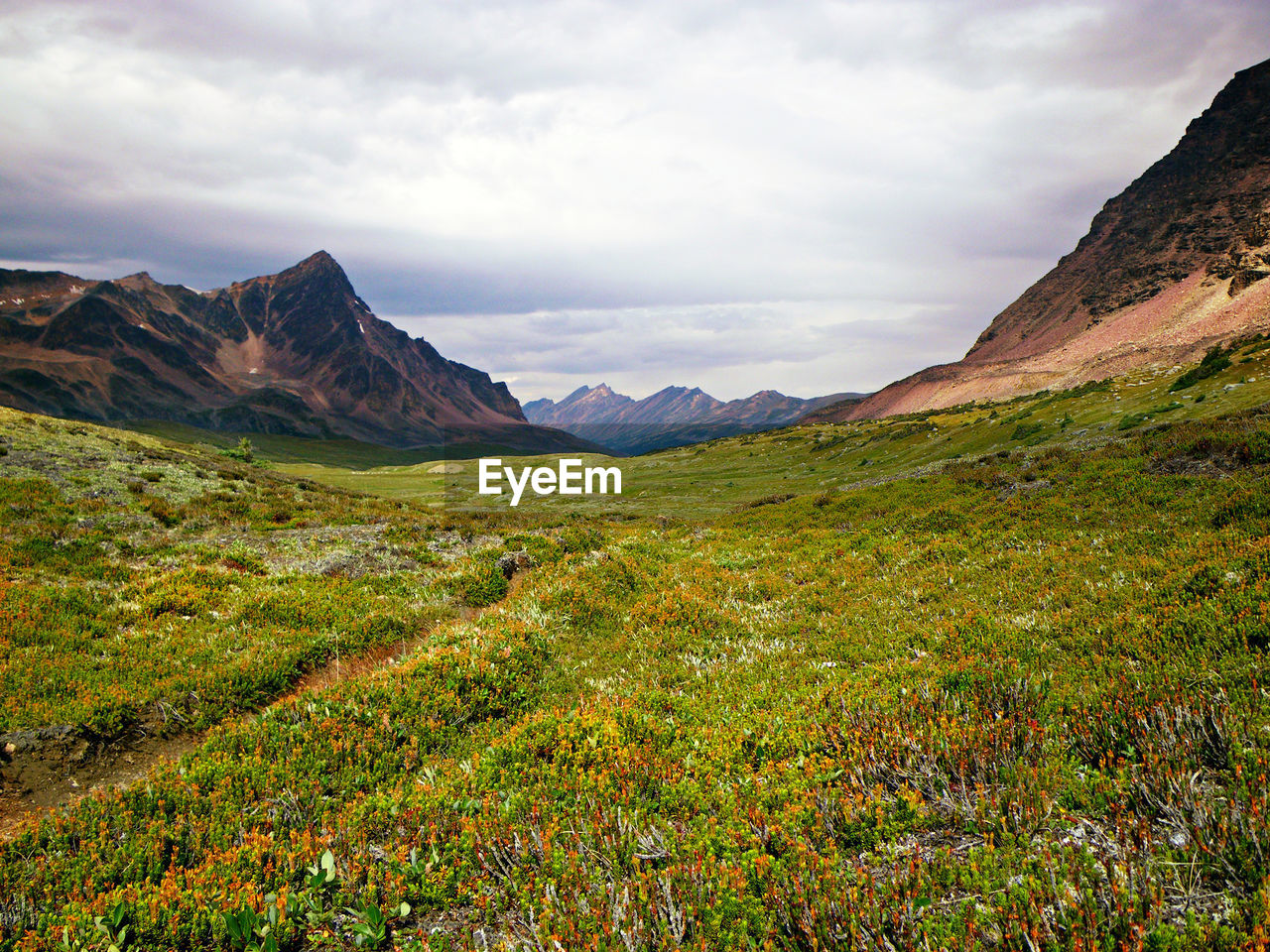 Scenic view of mountains against cloudy sky