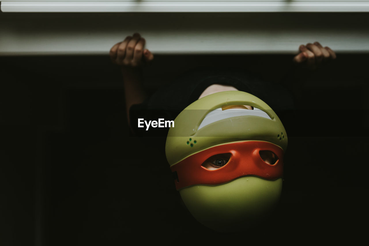 Close-up of boy wearing mask at home