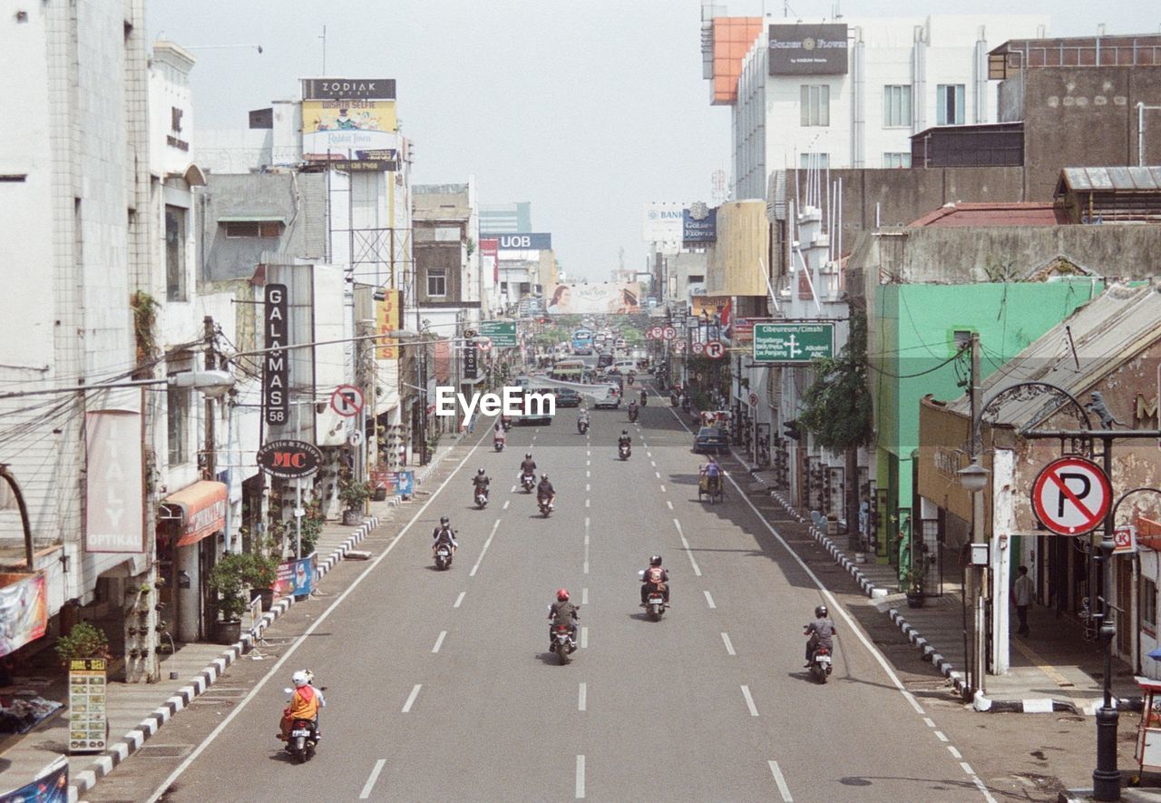 VEHICLES ON ROAD AGAINST BUILDINGS