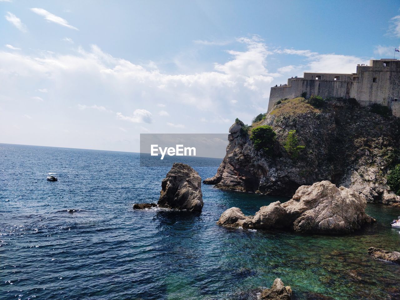 SCENIC VIEW OF ROCKS BY SEA AGAINST SKY