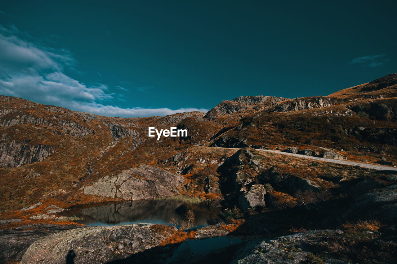 Scenic view of mountains against blue sky