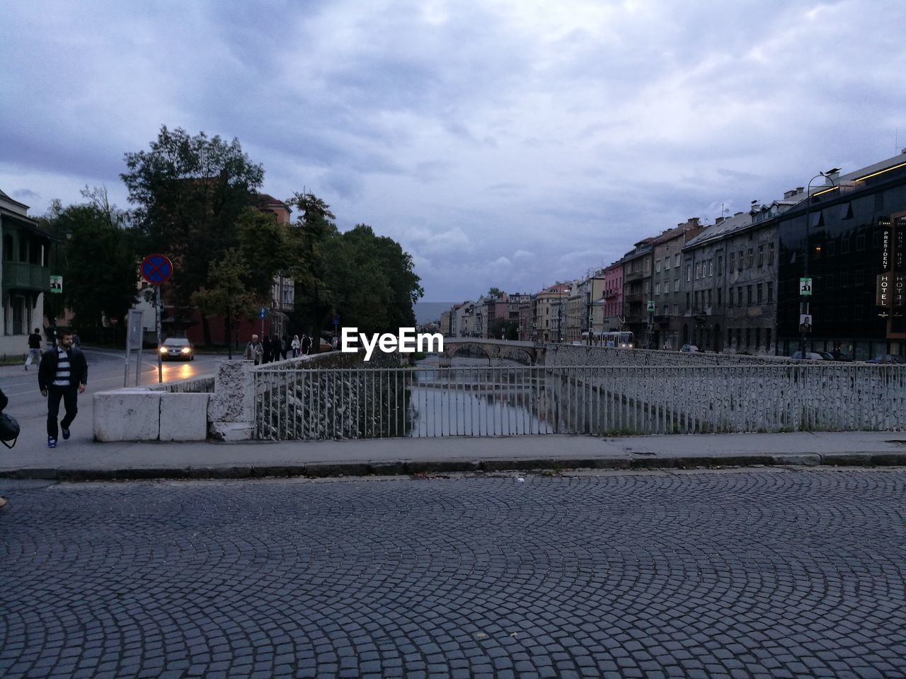 VIEW OF CITY STREET AGAINST CLOUDY SKY