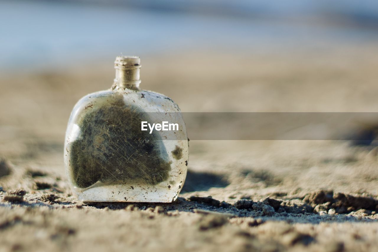 Close-up of small bottle with sand on the beach