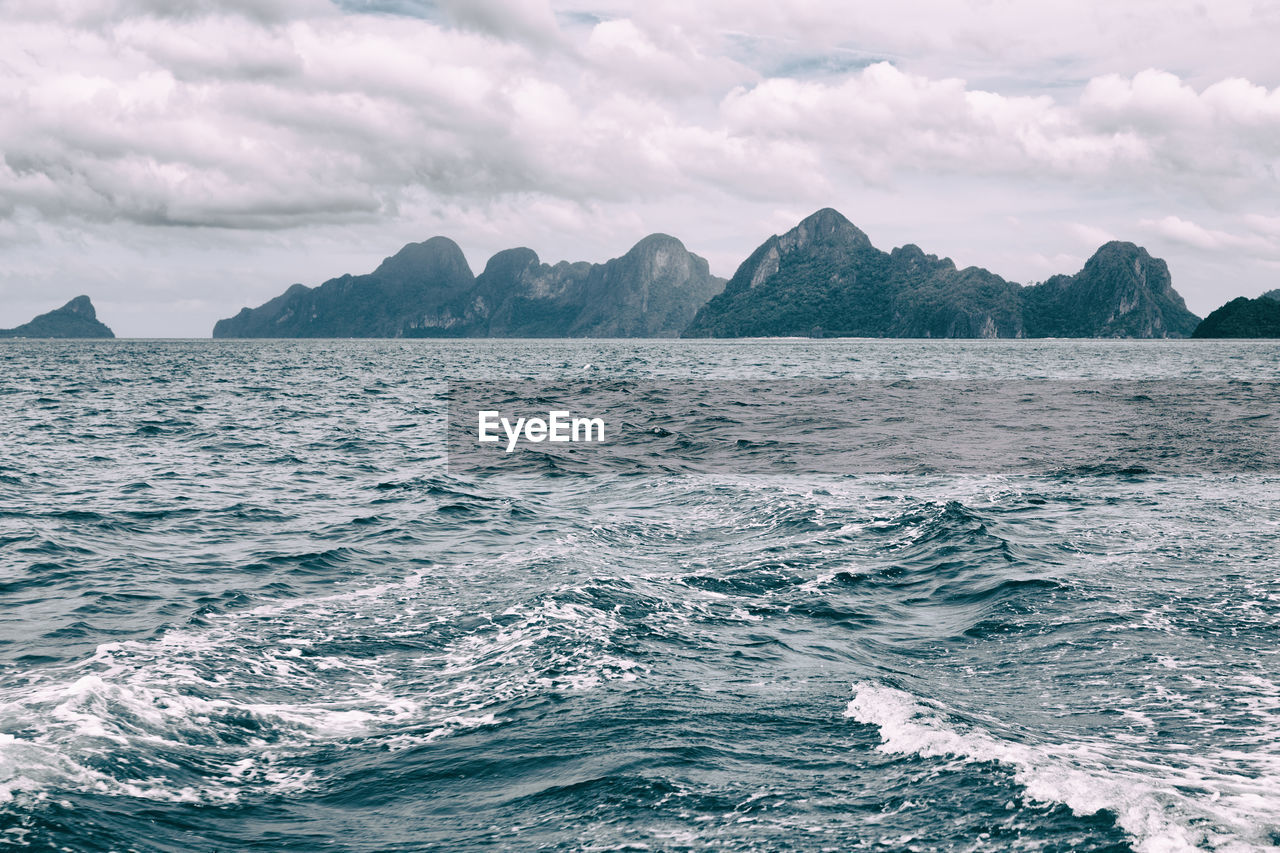 SCENIC VIEW OF SEA BY MOUNTAINS AGAINST SKY