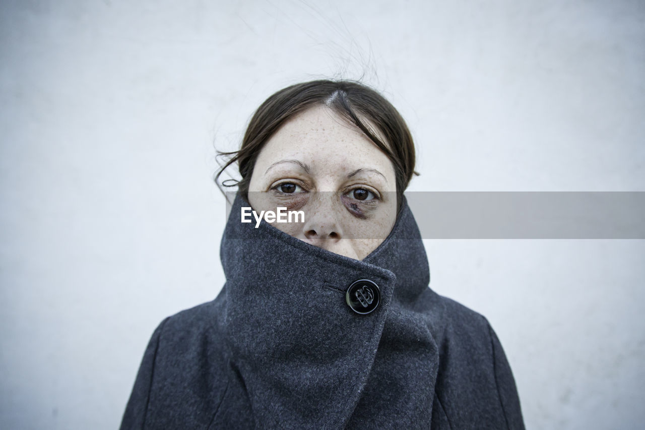 Portrait of woman standing against wall