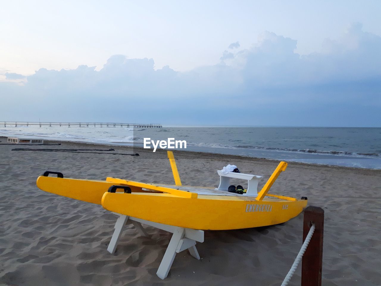 YELLOW SHIP IN SEA AGAINST SKY