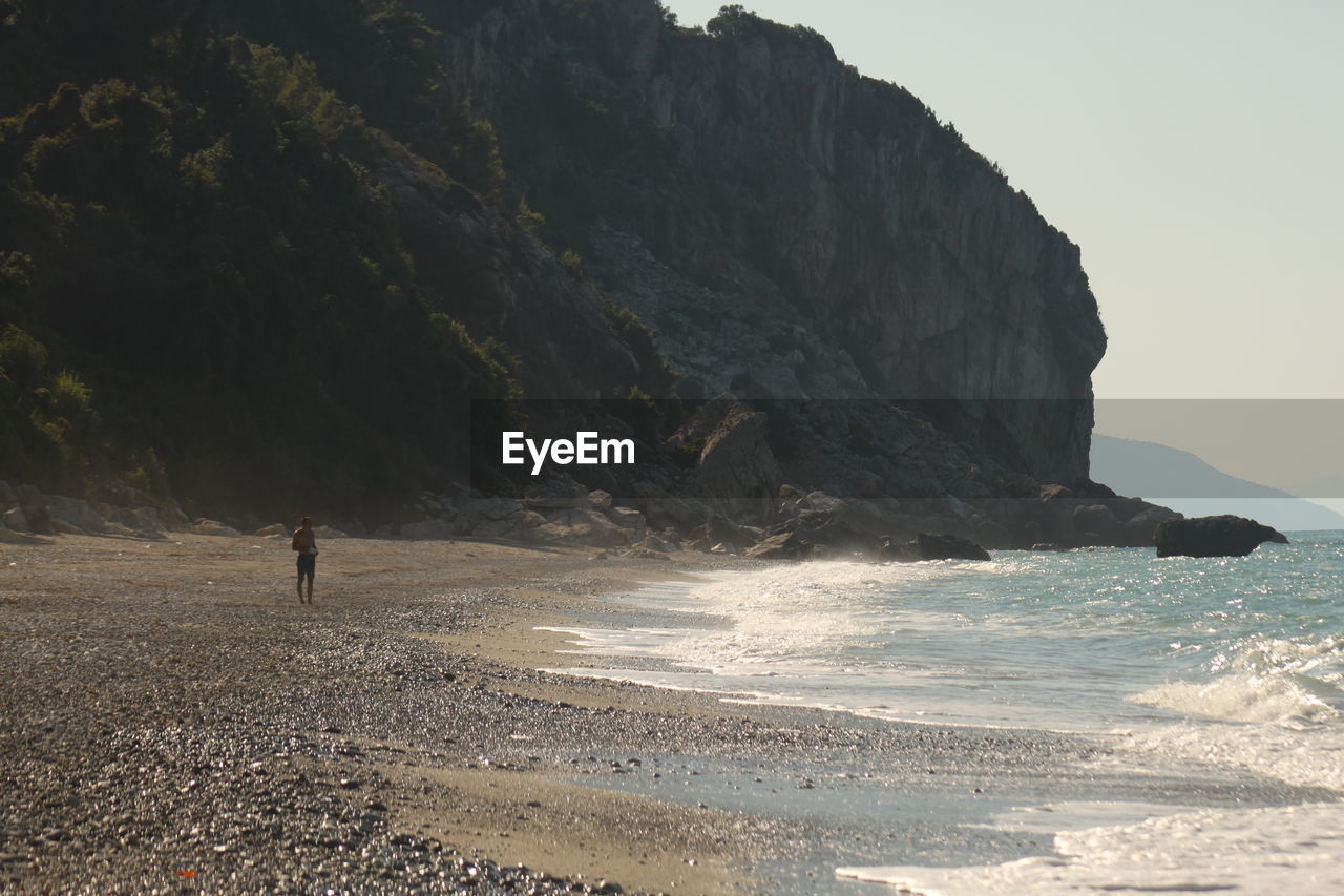 SCENIC VIEW OF SEA AGAINST MOUNTAIN