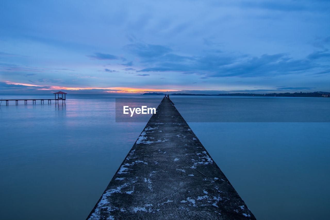 Pier on sea at sunset