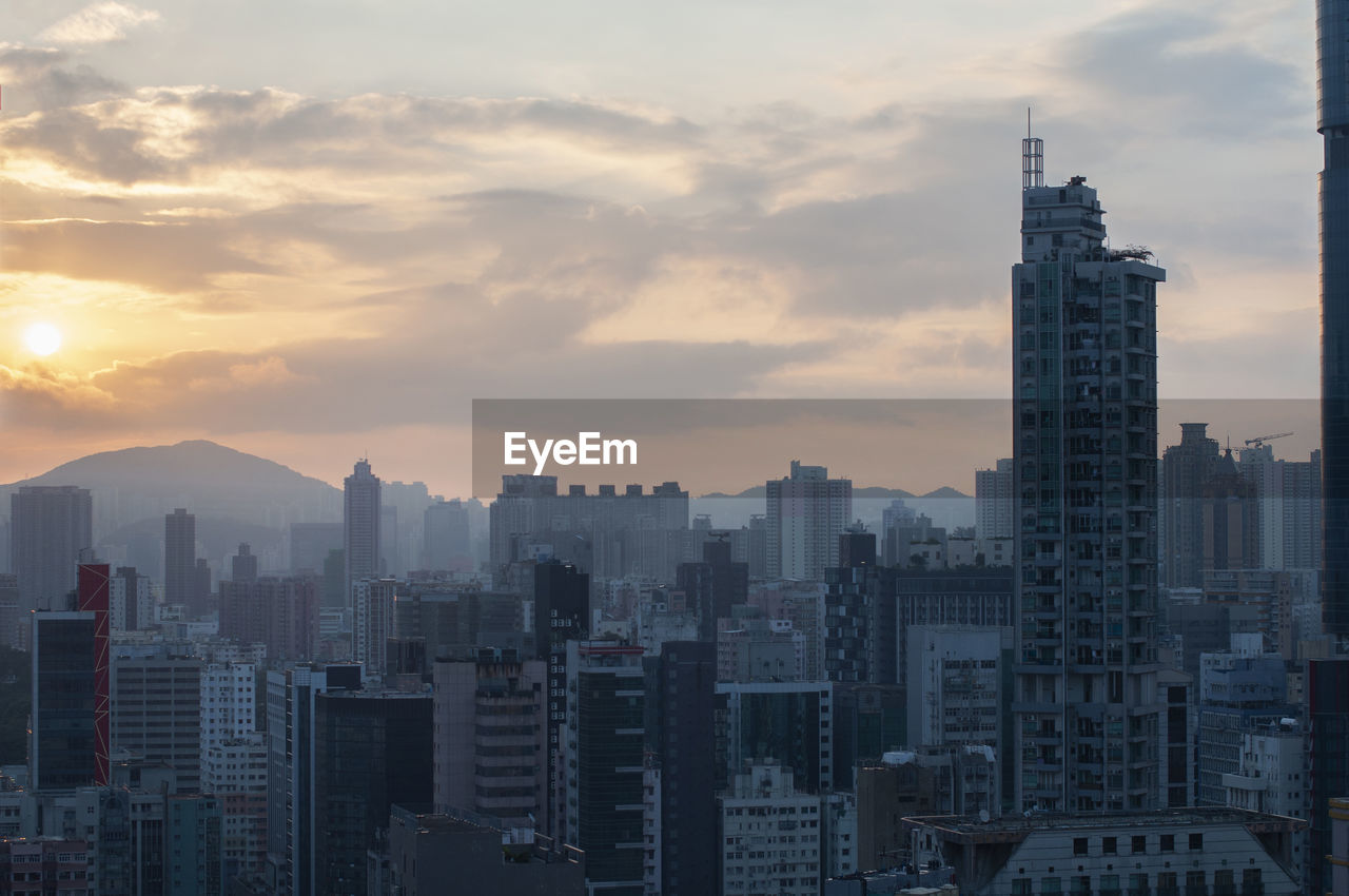 BUILDINGS IN CITY AGAINST SKY AT SUNSET