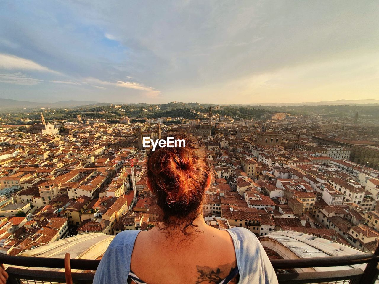 REAR VIEW OF WOMAN LOOKING AT CITYSCAPE