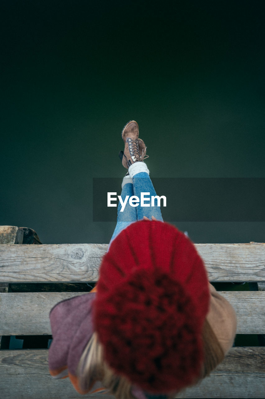 Directly above shot of woman sitting on pier over sea
