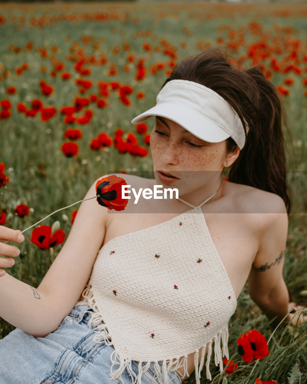 Woman looking at flower in field