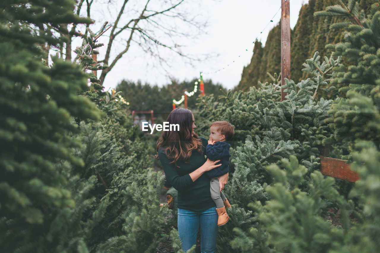 Mother and son amidst plants