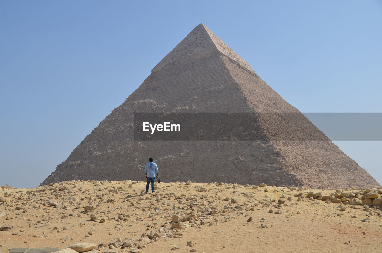 Man standing against pyramid