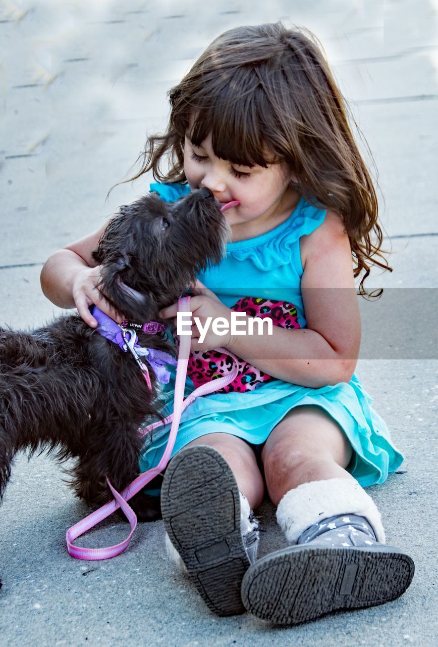 dog, pet, domestic animals, animal, animal themes, one animal, child, mammal, blue, childhood, canine, one person, person, puppy, carnivore, female, women, friendship, toddler, casual clothing, cute, full length, brown hair, clothing, day, emotion, fun, lap dog, sitting, leisure activity, hairstyle