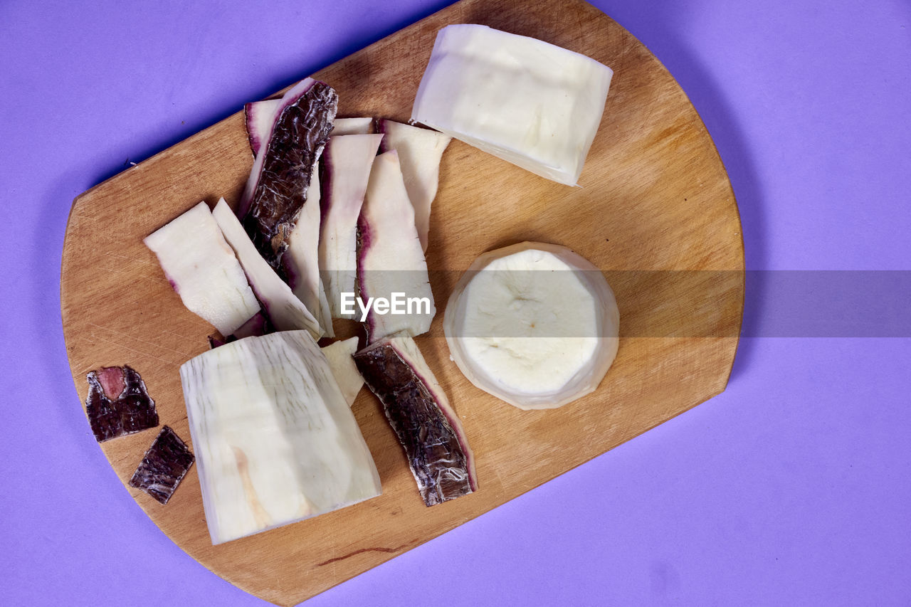 Fresh organic cassava root, manioc esculenta, yuca on purple background