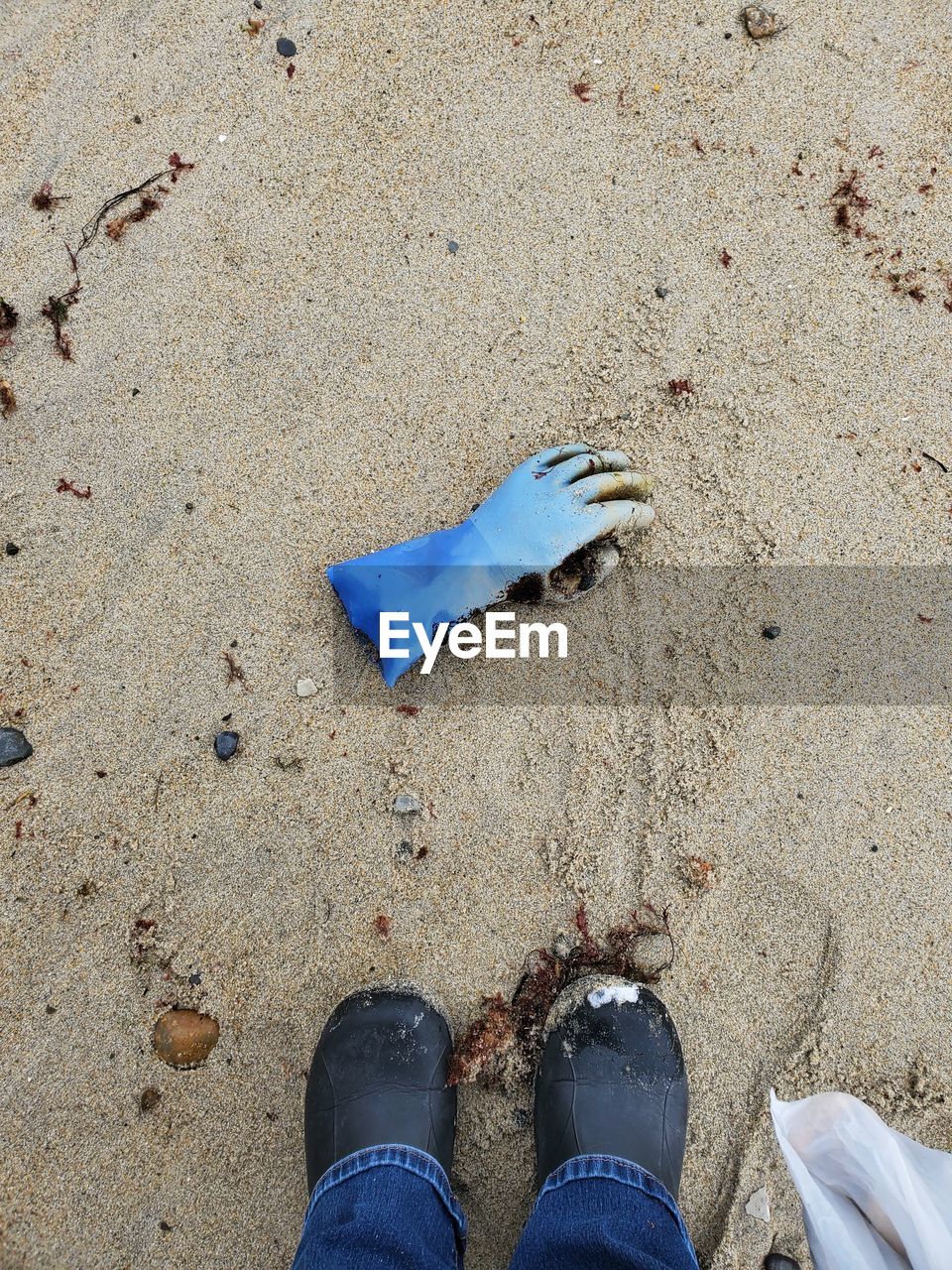 Low section of person standing on sand