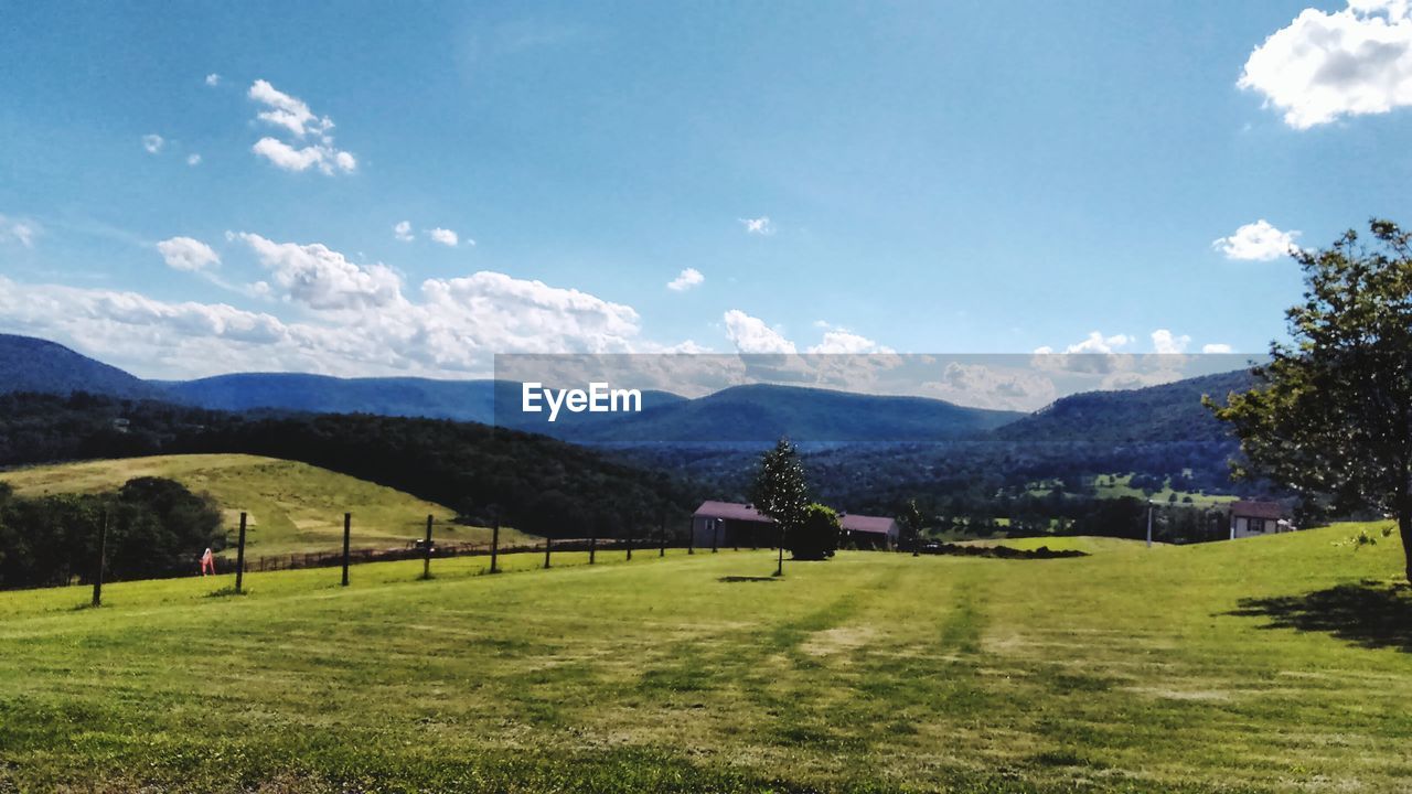 Scenic view of field and mountains against sky