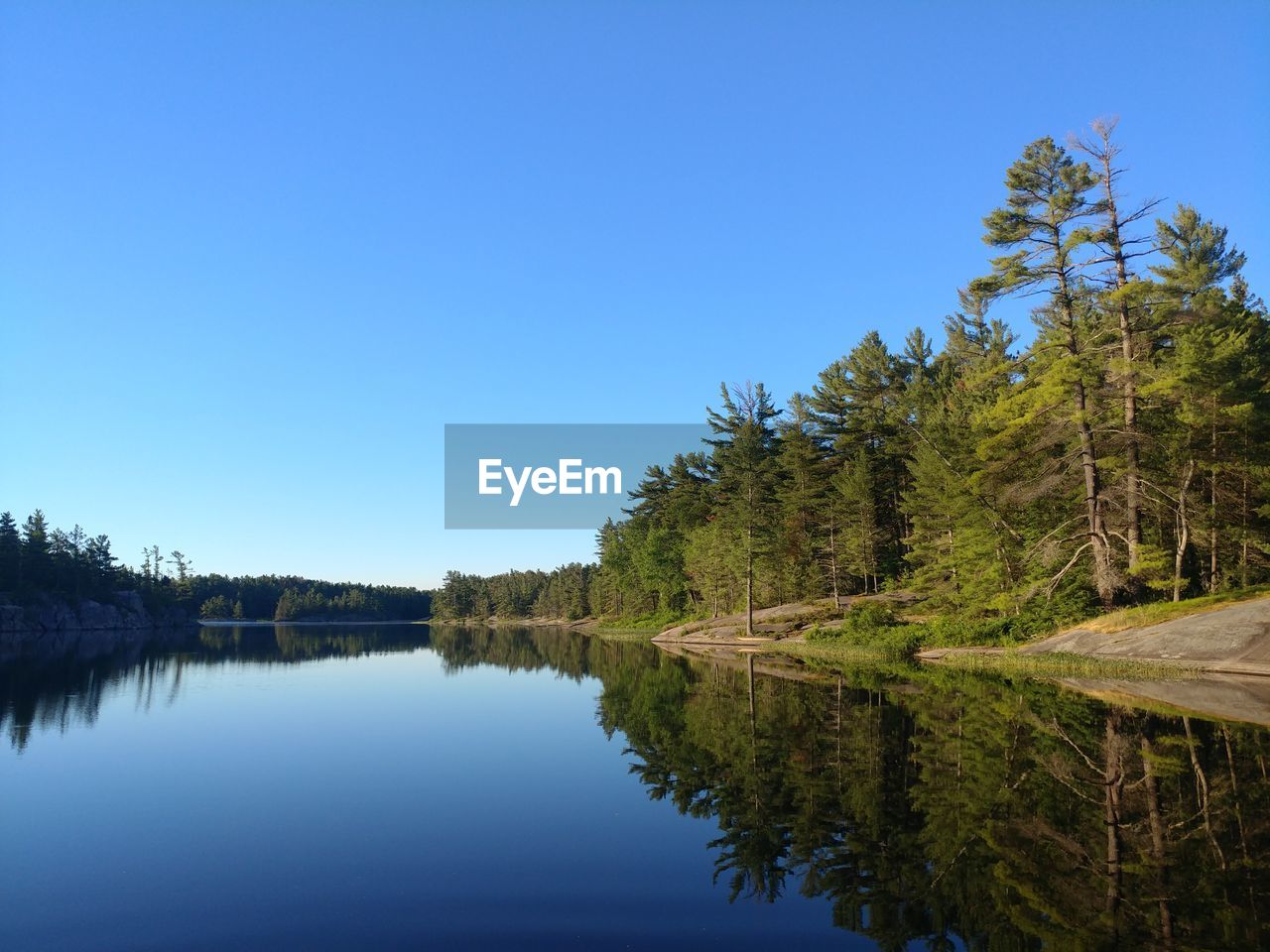 Scenic view of lake against clear blue sky