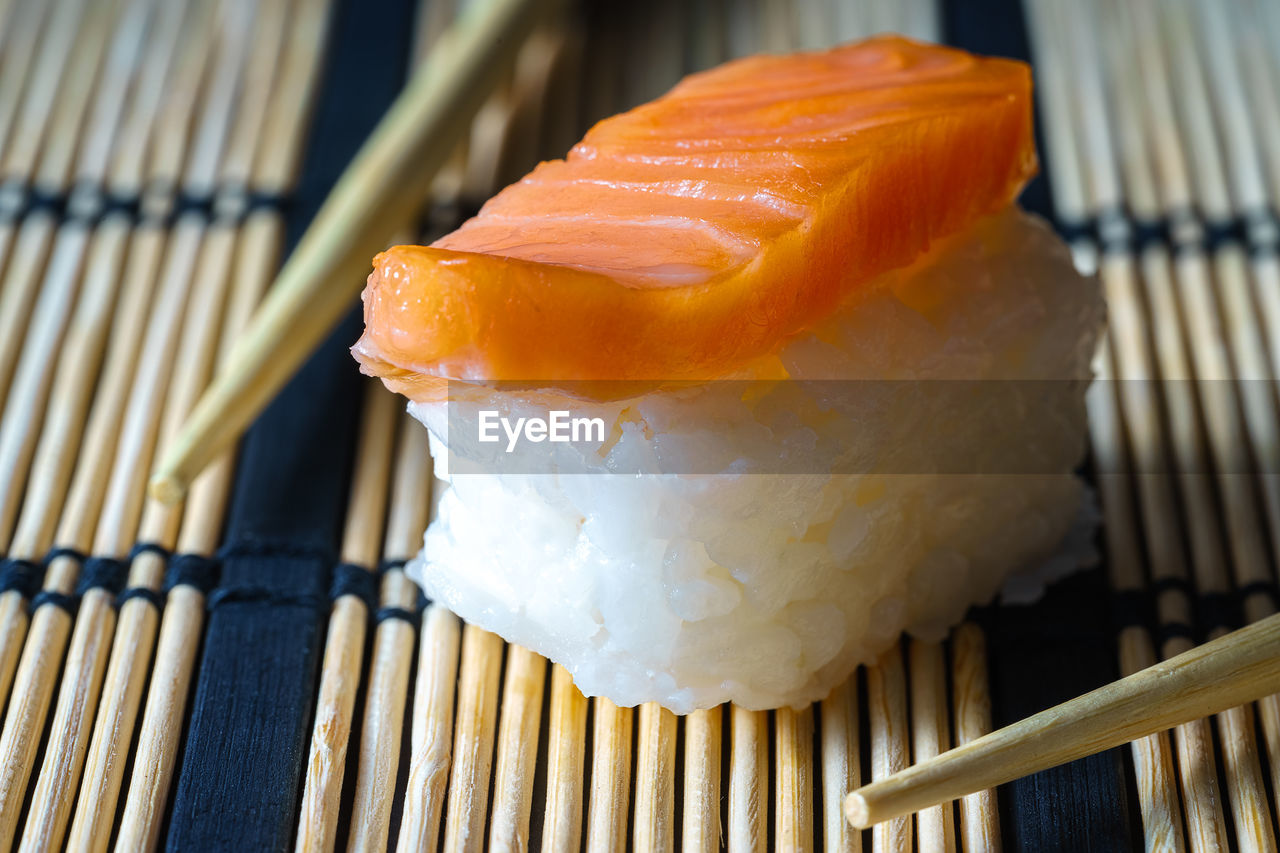 Close up healthy traditional japanese sushi set nigiri and rolls with chopsticks.