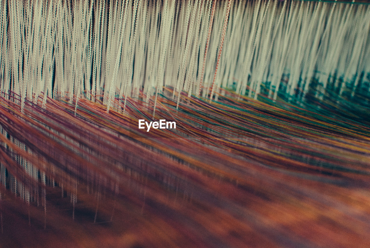 Close-up of threads on loom in textile factory